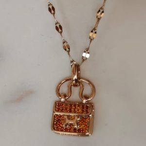Collar oro rosa maleta piedras rojas
